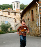boy-running-down-street-tuscany-with-kids
