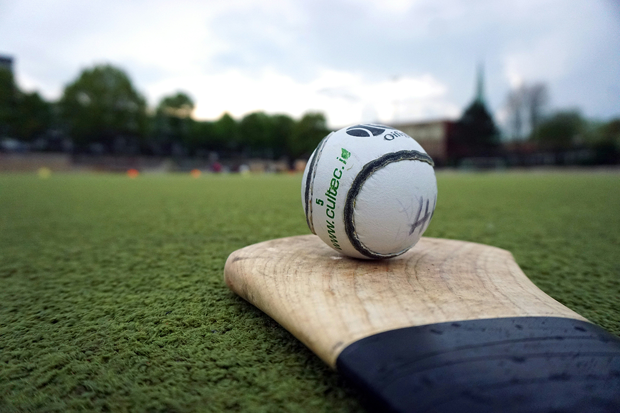 A sliotar and a hurley from the Irish sport of hurling. Photo by Adrian Payne on Unsplash