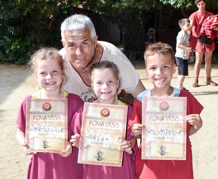 Adult with children holding awards