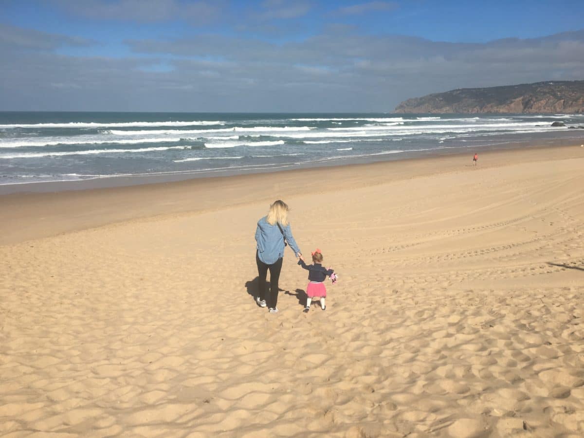 Woman and child walk on beach